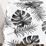 Tischdecke mit Monstera- und Palmenblatt-Design in Schwarz-Weiß auf hellem Hintergrund, ideal für moderne und minimalistische Tischdekorationen.