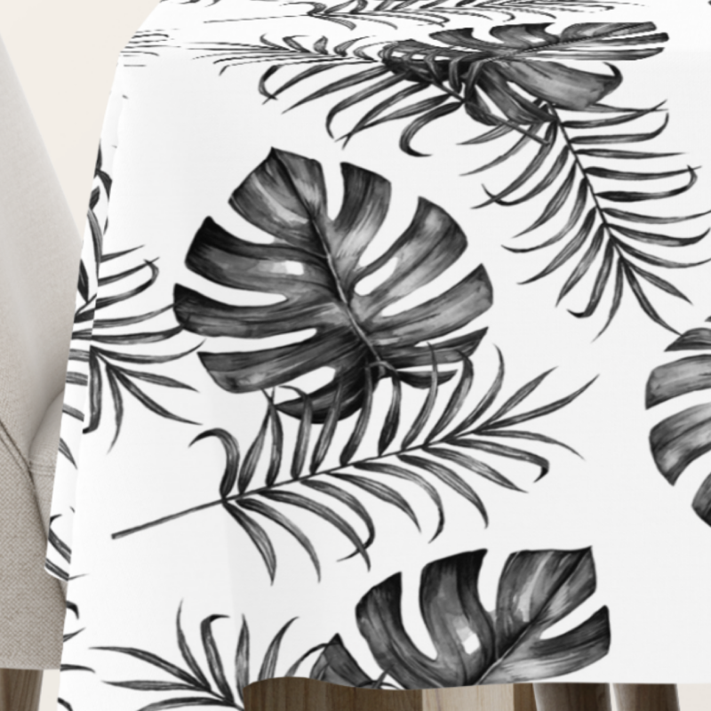 Tischdecke mit Monstera- und Palmenblatt-Design in Schwarz-Weiß auf hellem Hintergrund, ideal für moderne und minimalistische Tischdekorationen.